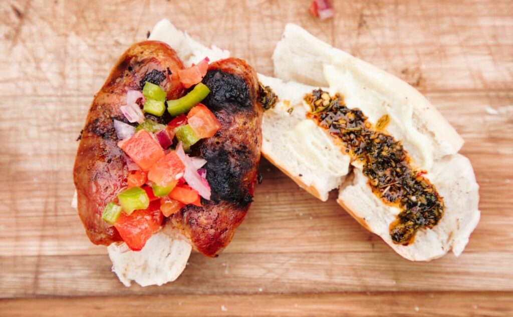 Choripán con salsa criolla y chimichurri, una comida típica de Argentina